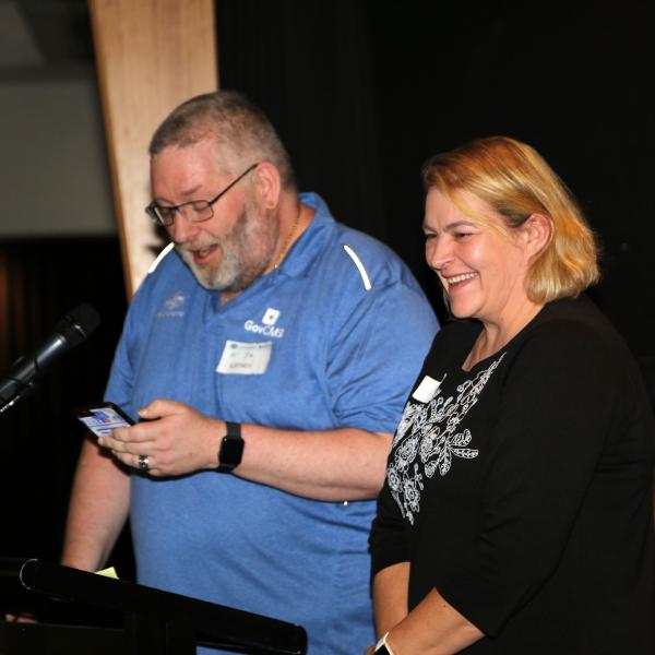 Nathan Wall and Sharyn Clarkson at a lectern presenting